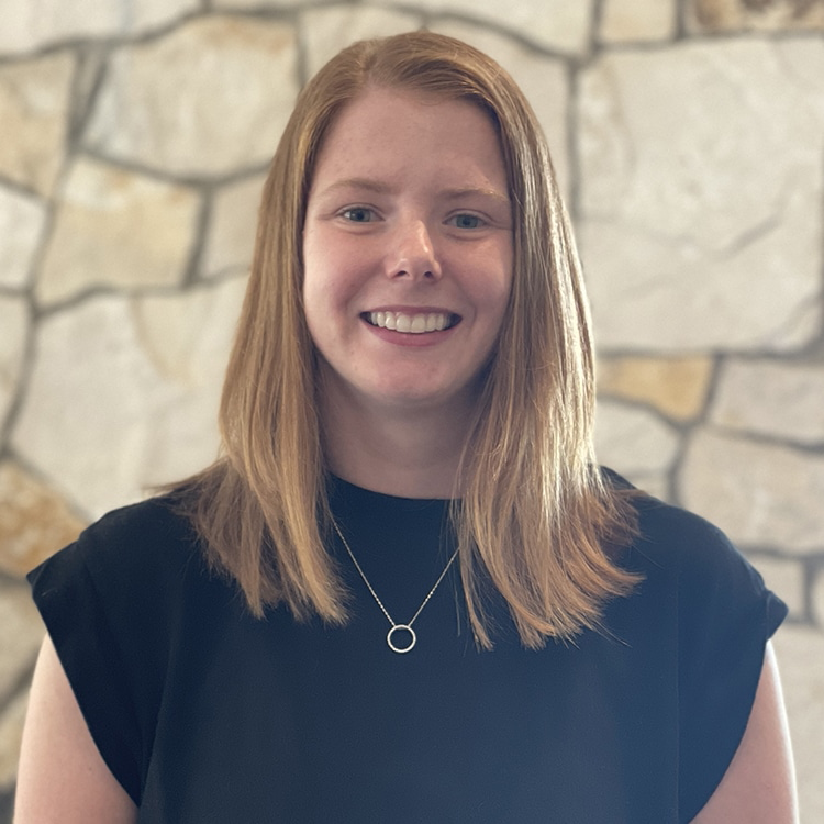 Jessie holding Koko, a service dog, on a snowy bridge