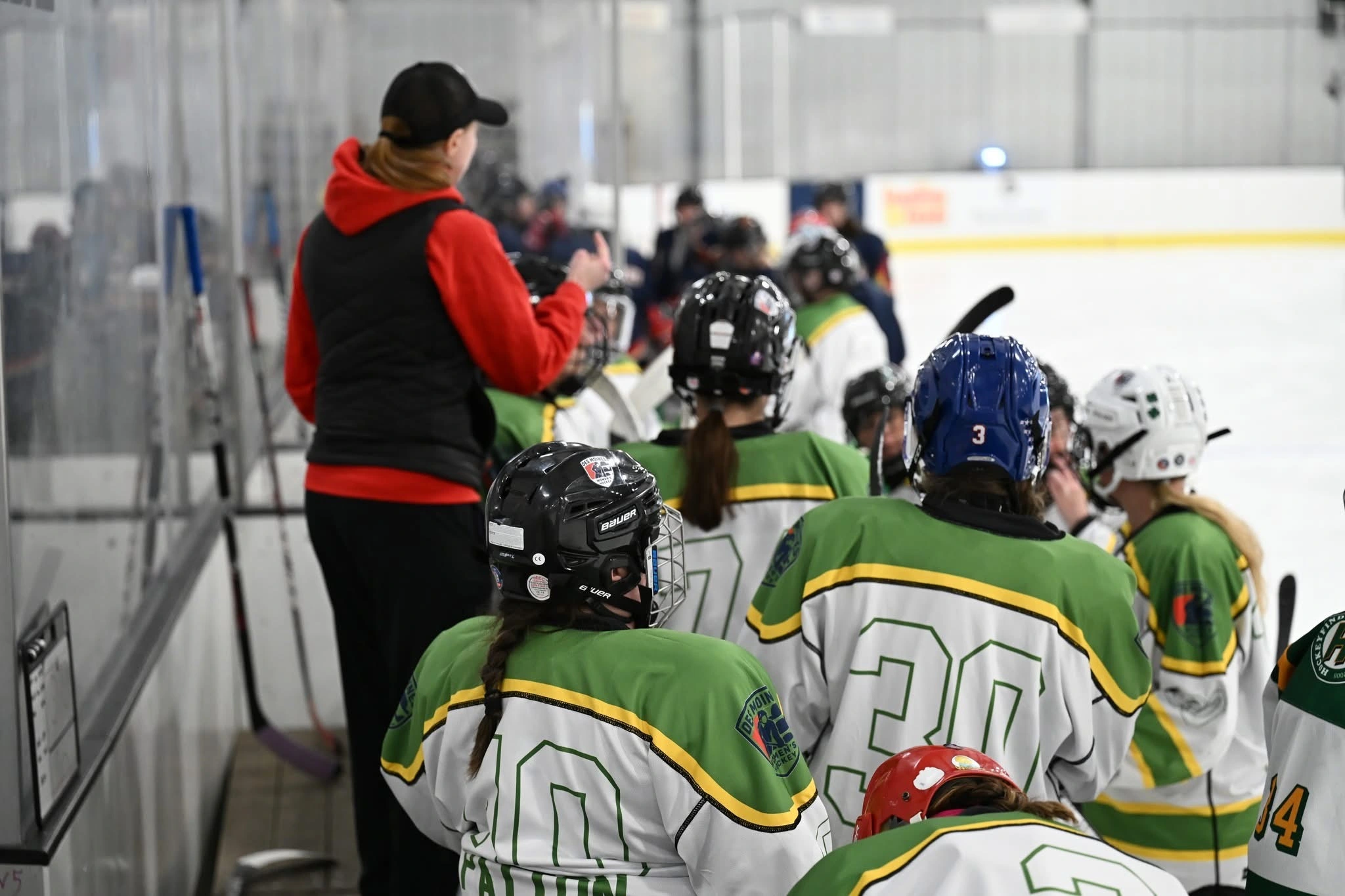 Jessie Rudin behind the bench coaching youth hockey