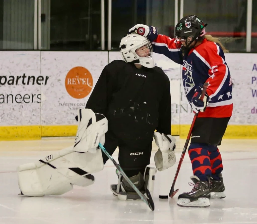 Jessie Rudin mentoring a young goaltender
